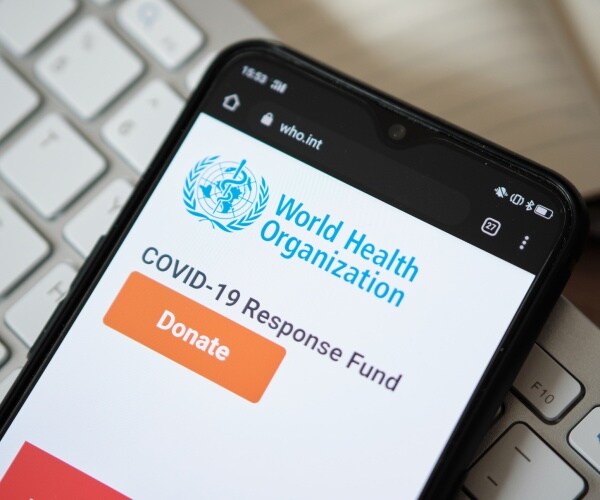 who logo on a smart phone with covid-19 response fund donation button