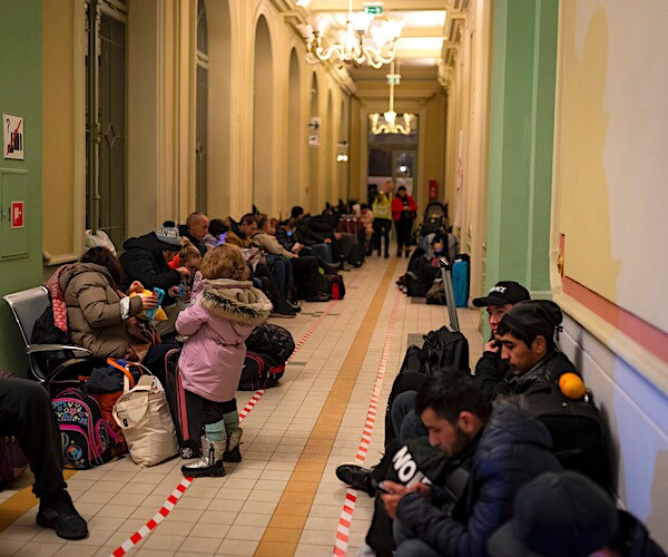 ukraine refugees are lined up on the floor of a long hallway