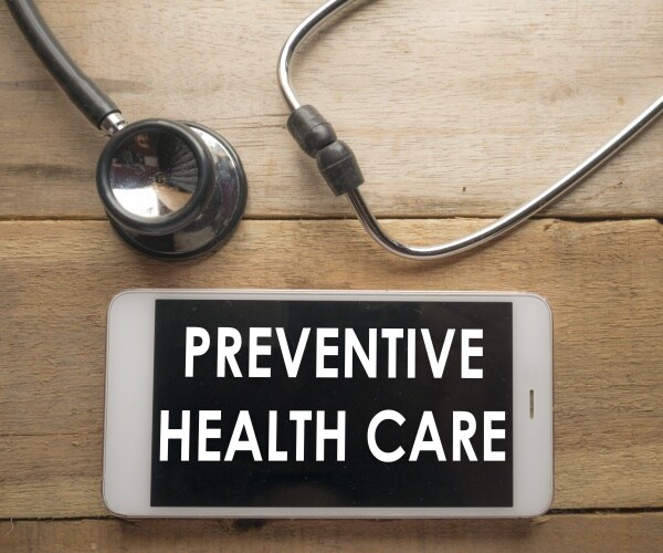 "Preventive Healthcare" on screen of phone, stethoscope