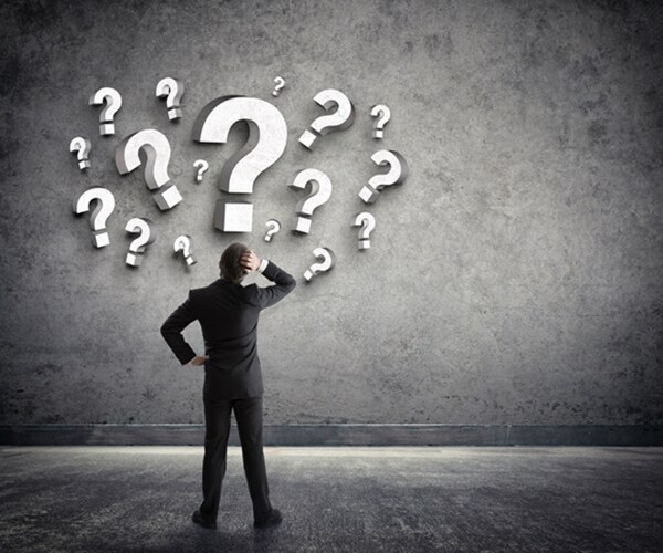 man scratching head with question marks above