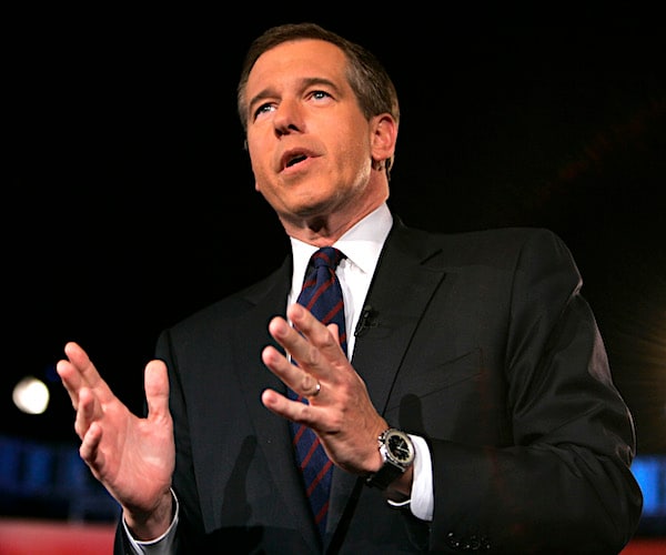 brian williams gestures with both hands while he speaks on stage