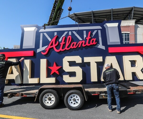 workers load sign onto truck