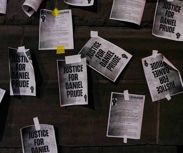 papers taped to a wall read justice for daniel prude