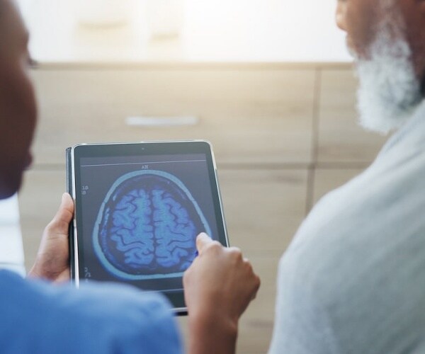 doctor showing patient brain scan