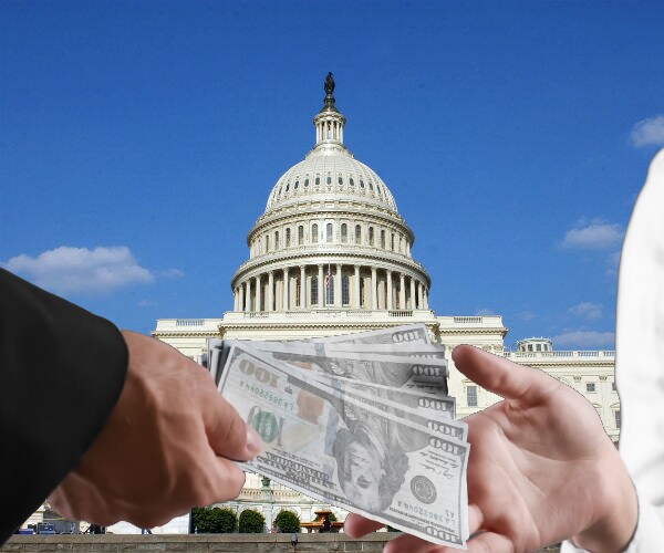 Two hands exchanging money with the united states capitol building in the background