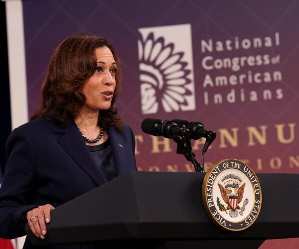 kamala harris speaks into podium mic