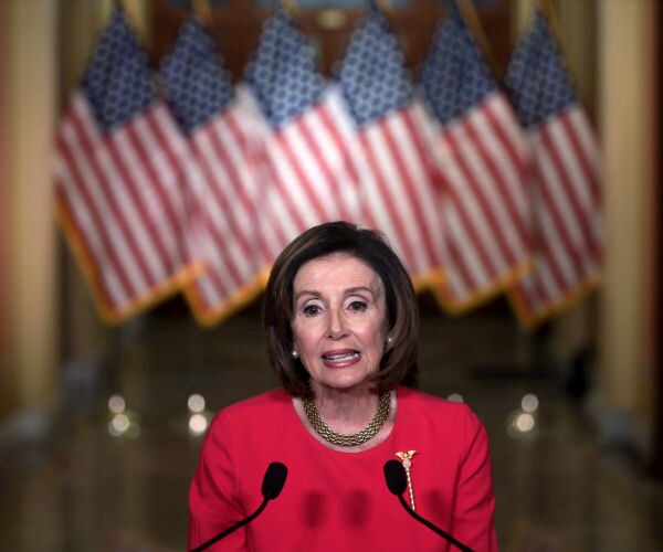 nancy pelosi is shown with american flags in the background