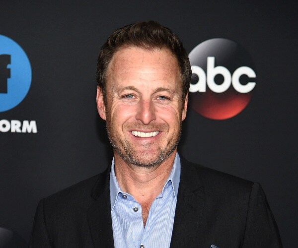 chris harrison stands on red carpet