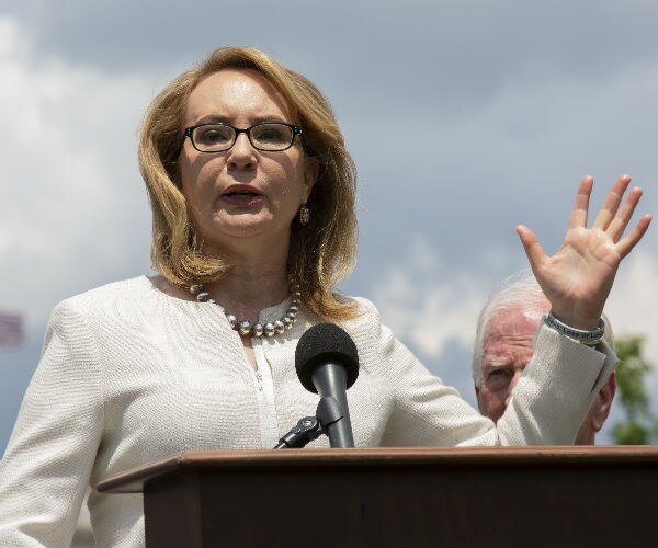 Former Congresswoman Gabby Giffords speaks at a rally in a white suit