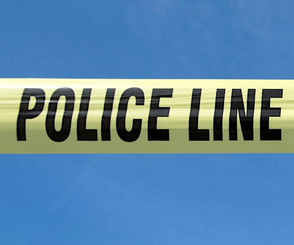 a yellow police tape against a clear blue sky