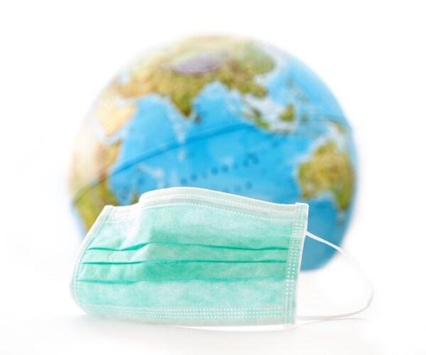 globe with a mask on table in front of it