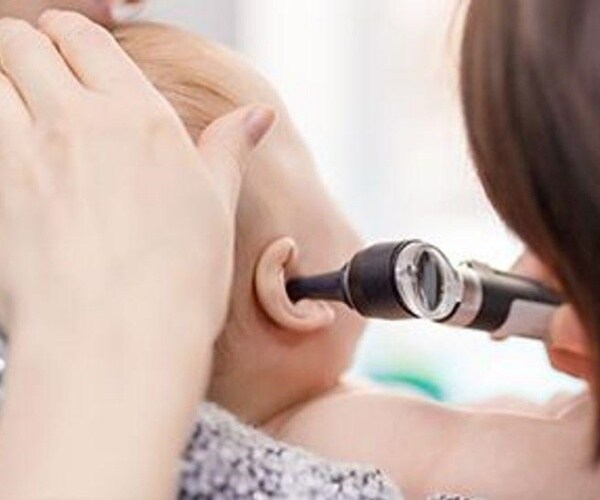 doctor looking in a baby's ear