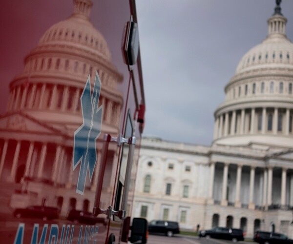 us capitol building reflected on a red ambulance with blue logo