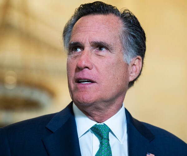 mitt romney in a navy blue suit and green tie looking up
