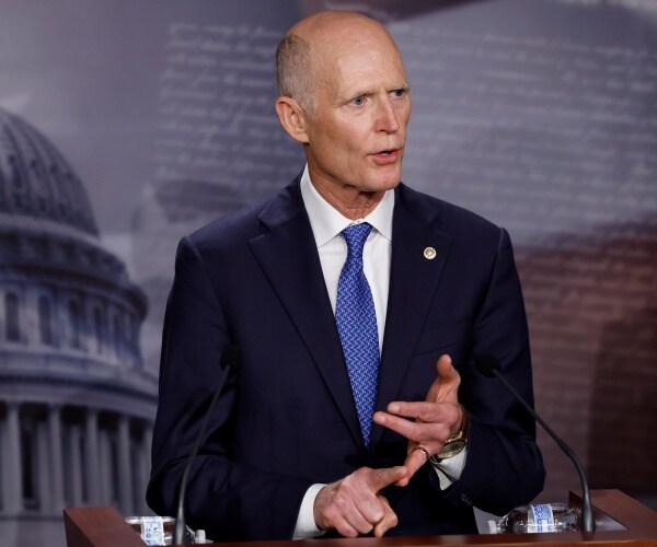 rick scott gestures while speaking