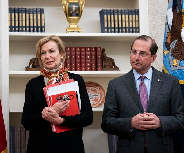 dr. birx and sec. alax azar stand next to each other in front of a book shelf