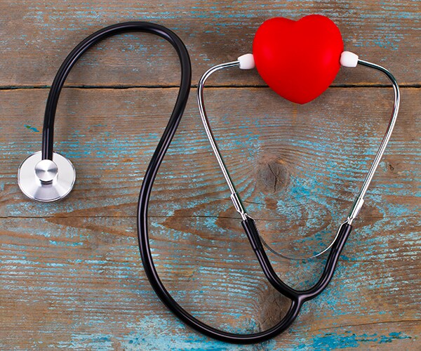 A stethoscope wrapped with a red heart