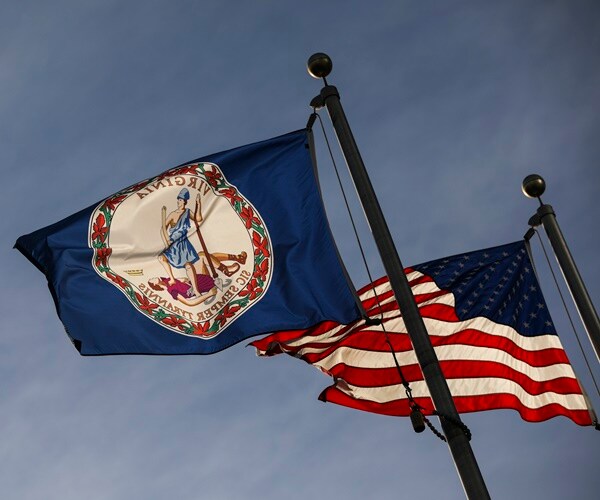 a virginia flag flies next to a u.s. flag