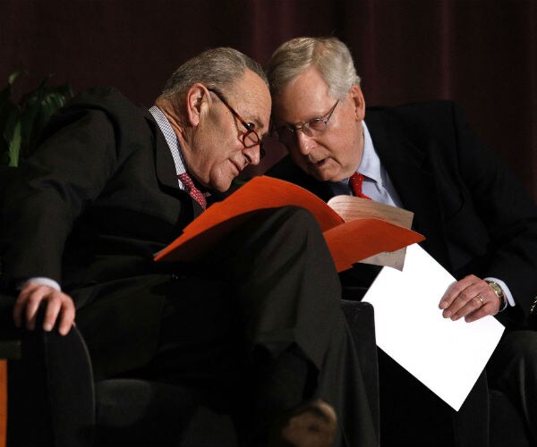 chuck schumer and mitch mconnell talking to each other during an event