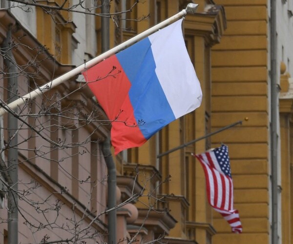 A Russian flag flies next to the U.S. embassy building in Moscow.