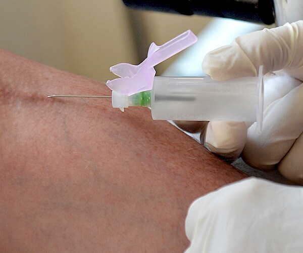 a blood test is administered by a nurse by a needle and a syringe