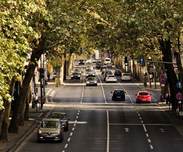 busy 4-lane road with trees on side