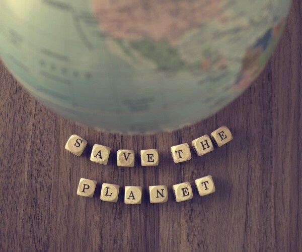  a globe on a wooden table and the word save the planet