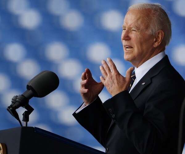joe biden speaks into a microphone