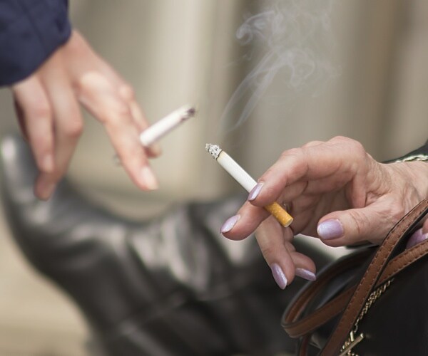 people holding cigarettes and wearing leather boots