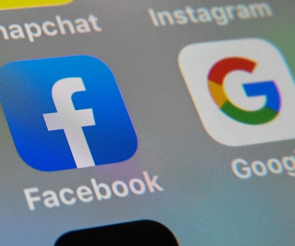 The logos of mobile apps Facebook and Google displayed on a tablet 