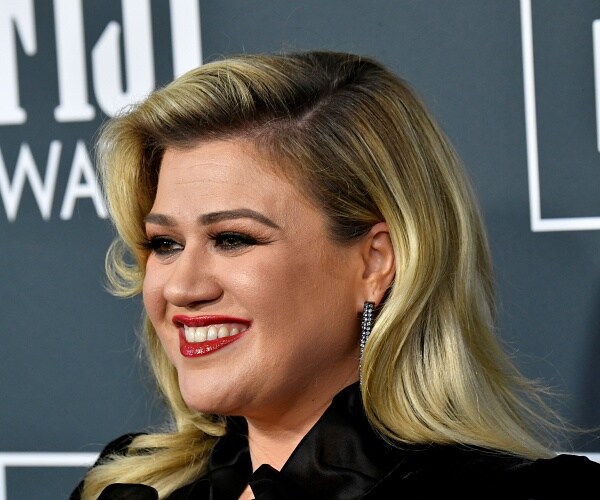 kelly clarkson stands on red carpet