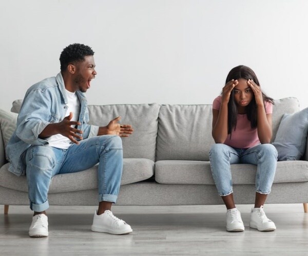 Father and daughter on couch, father yelling at daughter