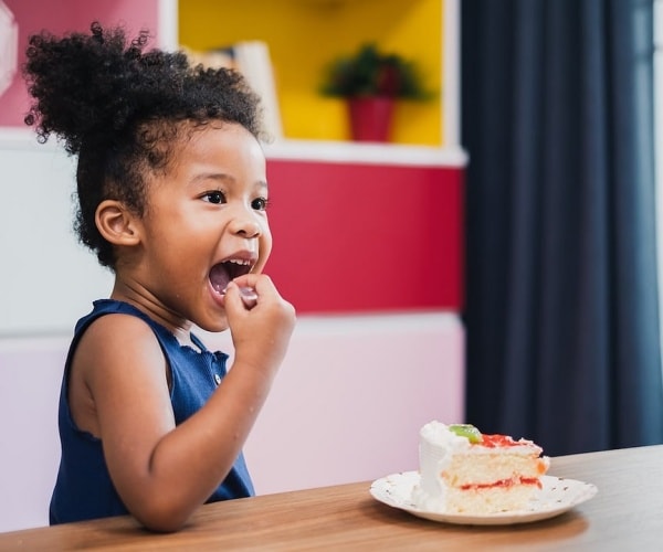 young toddler eating cake