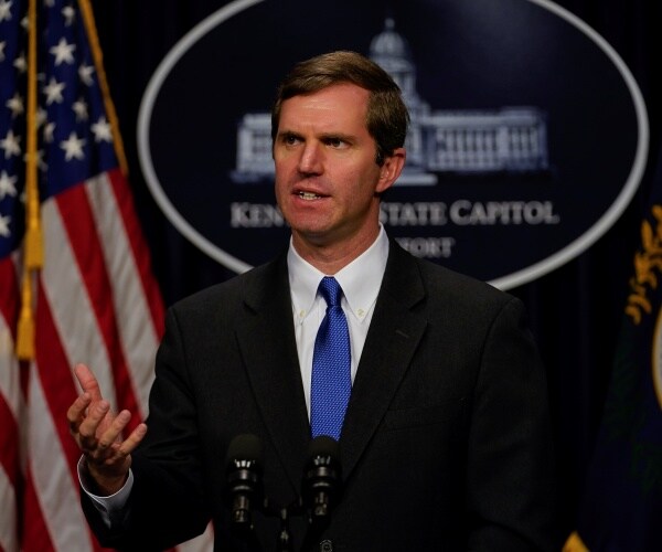 beshear in a black suit and blue tie