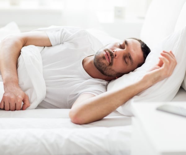 man sound asleep in bed