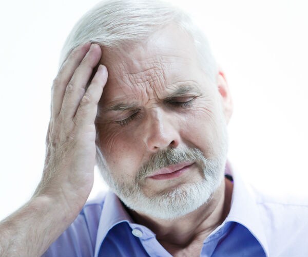 a man holding his head appearing to be in pain