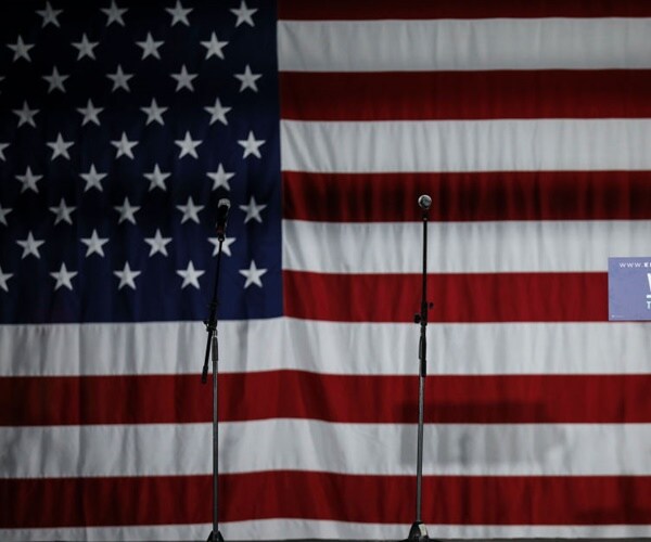 a mic stands in front of an american flag