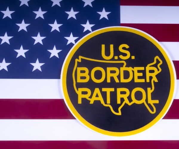 symbol of the us border patrol pictured over the us flag
