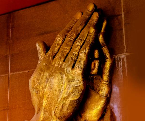 relief in wall of praying hands