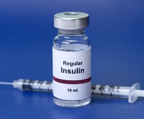 regular insulin with insulin syringe on blue background. 
