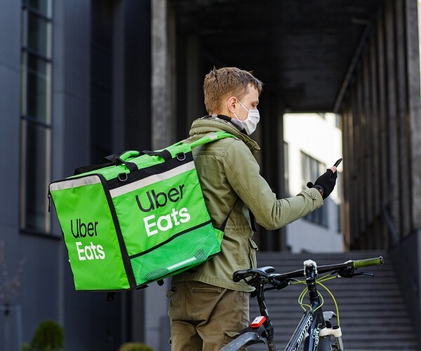 food delivery guy stands next to bike
