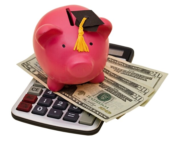 piggy bank wearing a graduation cap with twenty dollar bills and calculator on a white background