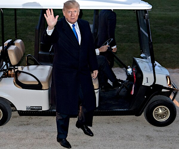 president donald trump waves coming out of a golf cart