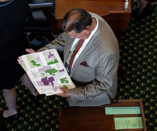 eddie lucio looks at colorful texas state map