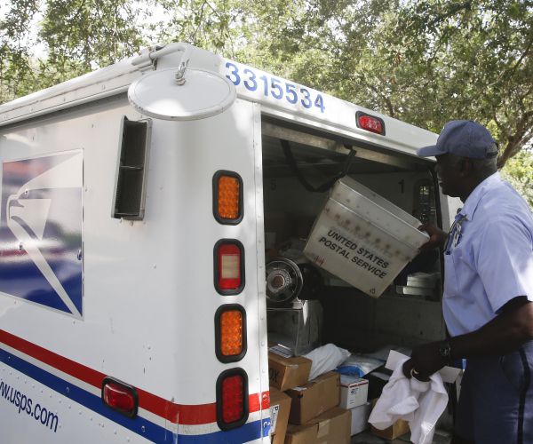 elston bradshaw, a mail carrier for the united states postal service, drops off packages.