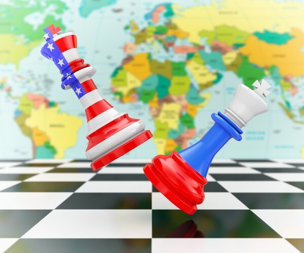 chess pieces painted as american and russian flags in front of a map of the world