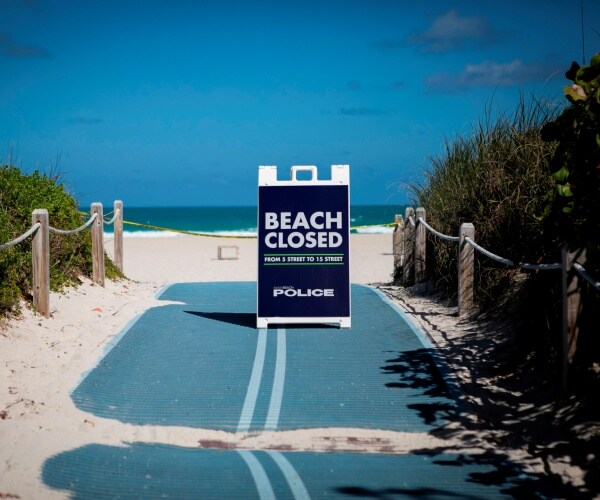 sign telling visitors the beach is closed is seen on a florida beach