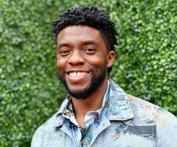 chadwick boseman stands on red carpet