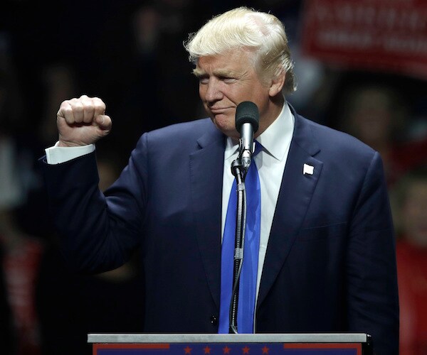 president donald trump turns to the right during a rally speech and pumps his right fist in the air triumphantly