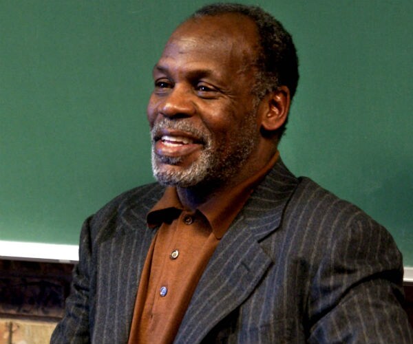 actor danny glover is shown in a pin stripped suit jacket and brown button down shirt